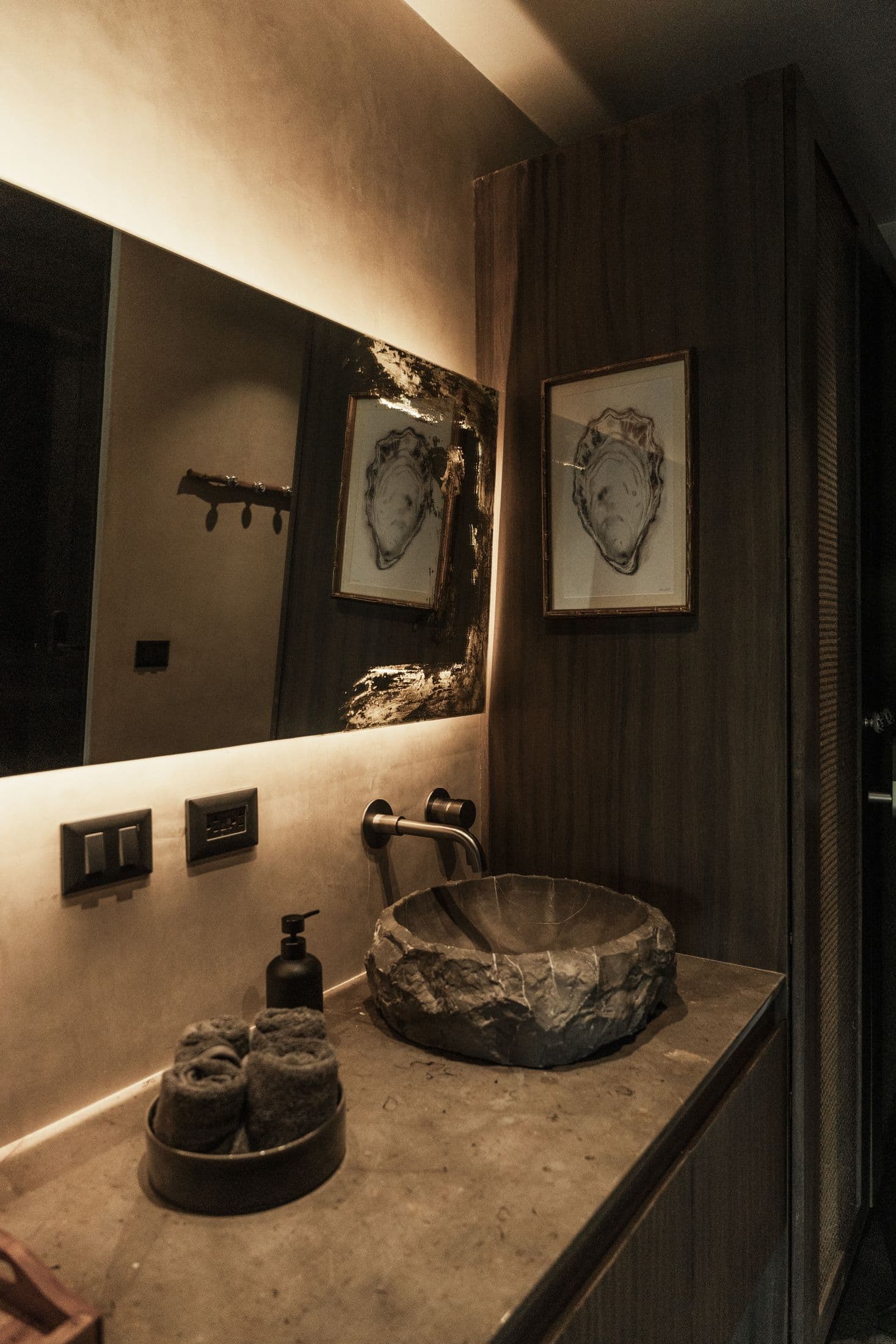 Lavabo de piedra con espejo iluminado